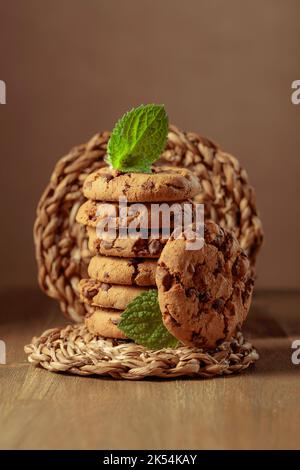 Biscotti al cioccolato appena sfornati con menta su un tavolo di legno. Foto Stock