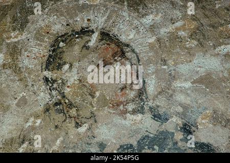 Volto di un santo. Particolare dell'affresco frammentario della Scuola di Giotto, dipinto nel 1300s. Nella Chiesa medievale di San Nicolò al Porto a Lazise, sul Lago di Garda, Veneto, Italia. Foto Stock