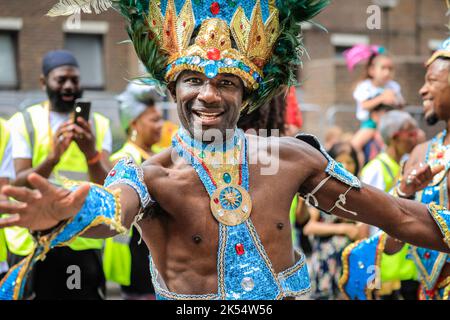 La ballerina samba maschile sorride in costume scintillante sorride alla macchina fotografica, Notting Hill Carnival, Londra, Regno Unito Foto Stock