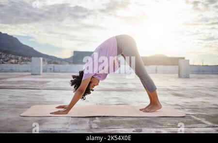 Yoga esercizio, tetto della città e donna che si piegano per l'equilibrio, il benessere e la salute in un edificio urbano al mattino. Fitness ragazza allenamento e. Foto Stock