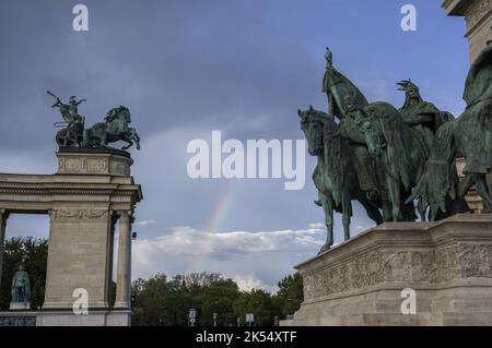 Andrassy Avenue a Budapest, Ungheria, in Piazza degli Eroi, Hősök tere. I sette capitani dei Magyar e la statua femminile di pace e un arcobaleno Foto Stock