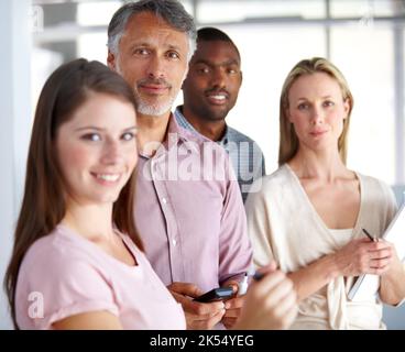 La mia squadra non mi lascia mai giù. Ritratto di un gruppo eterogeneo di colleghi in ufficio. Foto Stock