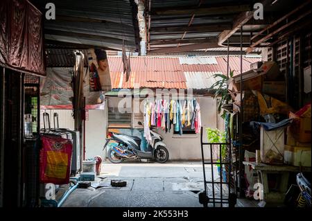 Guardando attraverso uno stretto vicolo tra le strette stradine dell'area della Comunità Soi Ruamrudee a Bangkok, Thailandia. Foto Stock
