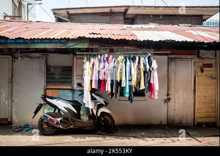 Vestiti appesi ad asciugare fuori di una piccola casa nel quartiere di Soi Ruamrudee Community Bangkok, Thailandia. Foto Stock