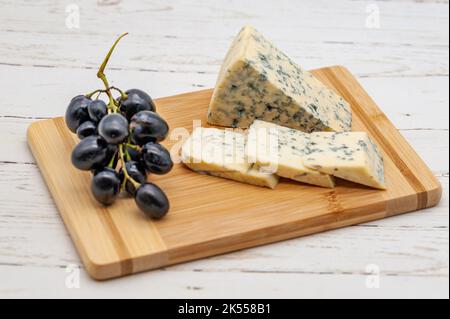 formaggio blu su tavola di legno con uva Foto Stock