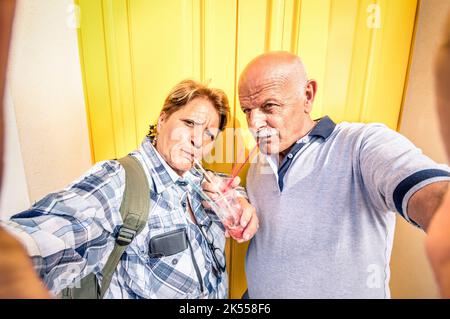 Coppia anziana felice che prende un selfie mentre mangia un gelato schiacciato granita - concetto di giovane anziano attivo e l'interazione con le nuove tecnologie Foto Stock