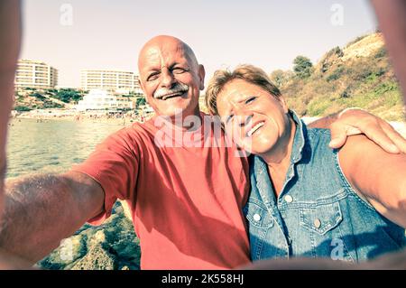 Coppia anziana felice che prende un selfie al resort Blue Grotto sulla costa sud di Malta - viaggio avventuroso verso le isole del mediterraneo - concetto di anziani attivi Foto Stock