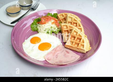 Uova con prosciutto e insalata e waffle belgi primo piano Foto Stock