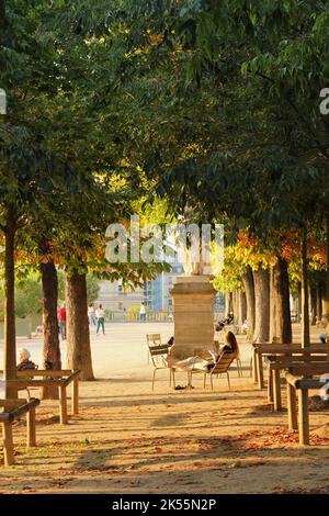 Donna che legge + si rilassa in una serata di tarda estate ai Giardini di Lussemburgo a Parigi. Esempio di stile di vita calmo che porta alla longevità e alla buona salute. Foto Stock