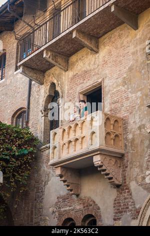 Balcone di Verona, vista di una giovane coppia che si erge sul balcone della Casa di Giulietta situata nel centro storico di Verona Foto Stock