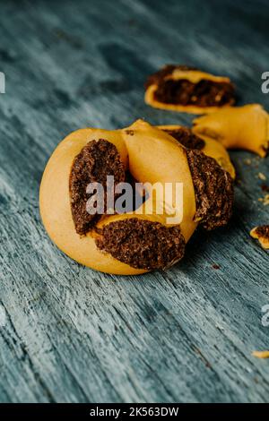 Primo piano di alcuni qaghaq tal-ghasel, dolci tipici di Malta, noti anche come anelli di miele in inglese, su un tavolo di legno grigio Foto Stock