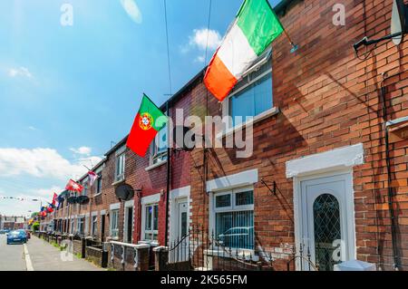 BELFAST, IRLANDA DEL NORD. 04 GIU 2016: Le case di Iris Drive a West Belfast sono decorate con le bandiere di tutti i 24 paesi che si sono qualificati per l'Euro 2016. I residenti hanno organizzato un sweepstake, con ogni casa che deve volare la bandiera del loro paese. Si ritiene che sia la prima volta che le bandiere dell'Inghilterra e dell'Irlanda del Nord sono volutamente volate in questa zona repubblicana di Belfast occidentale. Foto Stock