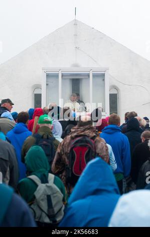 Le persone celebrano la messa nella chiesa in cima a Croagh Patrick la domenica di Reek, quando i pellegrini cattolici romani salgono in cima per seguire i passi di San Patrizio. Foto Stock