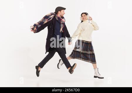 Ritratto di giovani alla moda, uomo e donna in abiti invernali allegri camminando insieme. Data romantica Foto Stock