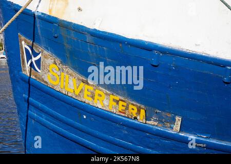 Targhetta con il nome e saluta sulla prua del peschereccio Silver Fern nel porto di East Loch Tarbert, Argyll e Bute. Scozia Foto Stock