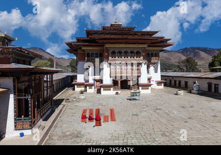 Phobjikha, Bhutan. I monaci buddisti seduto nel cortile del monastero Gangte Goemba (). Foto Stock