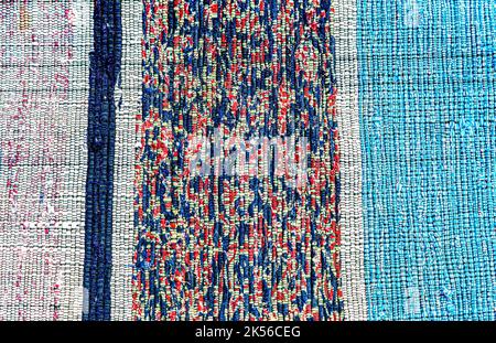 Vintage homespun zerbino costituito da strisce di stoffa come sfondo. La tessitura di un tappeto in casa da diversi tessuti Foto Stock