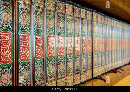 Fila ordinata di libri sacri del Corano su una mensola nella moschea del Sultano Qaboos a Salalah, Oman Foto Stock