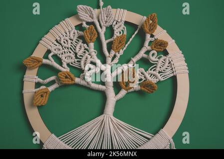 Albero di vita macrame fatto a mano a forma di cerchio decorazione parete senape foglie piume radici cotone stringa macramé nodo tecniche appeso parete Foto Stock