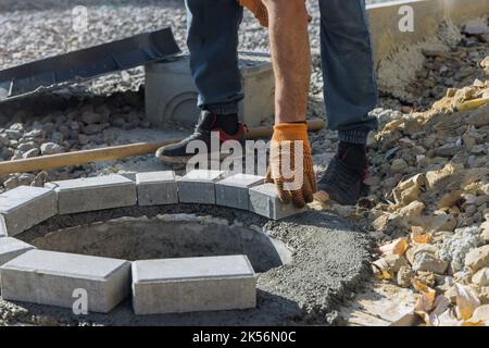 Lavoratore che costruisce una buca per un serbatoio settico fogna tombola ricostruzione di tubi di liquame in una trincea Foto Stock