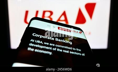 Telefono cellulare con pagina web della società United Bank for Africa PLC (UBA) sullo schermo di fronte al logo aziendale. Messa a fuoco in alto a sinistra del display del telefono. Foto Stock