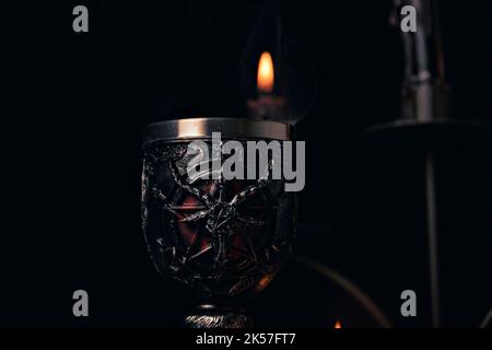 Composizione stregoneria con candele bruciate, gioielli e pentagramma simbolo. Halloween e concetto occulto, rituale magia nera. Foto Stock