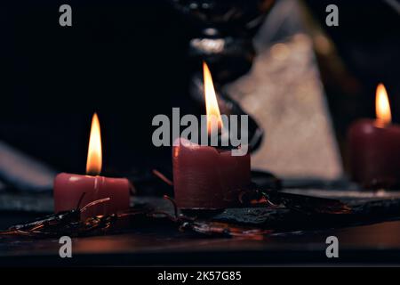 Composizione stregoneria con candele bruciate, gioielli e pentagramma simbolo. Halloween e concetto occulto, rituale magia nera. Foto Stock