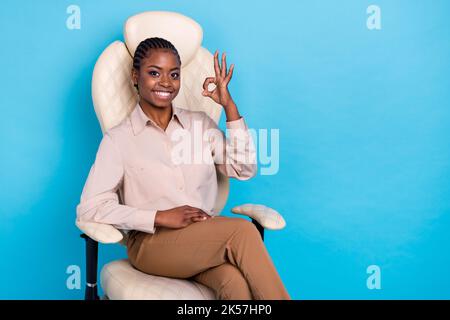 Foto di intelligente donna di affari mostra OK segno promuovere la sua posizione di lavoro isolato su sfondo di colore blu Foto Stock