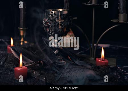 Composizione stregoneria con candele bruciate, gioielli e pentagramma simbolo. Halloween e concetto occulto, rituale magia nera. Foto Stock