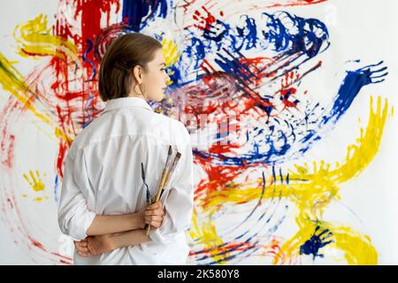 arte terapia pittura a mano donna con parete colorata Foto Stock