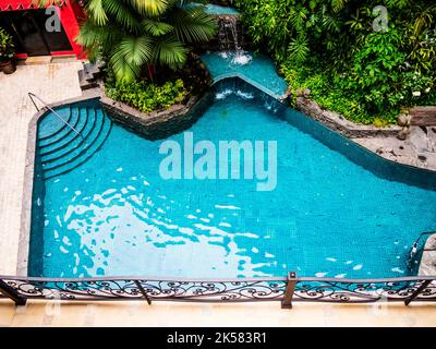 Splendida vista aerea di una piscina con alberi tropicali tutto intorno Foto Stock