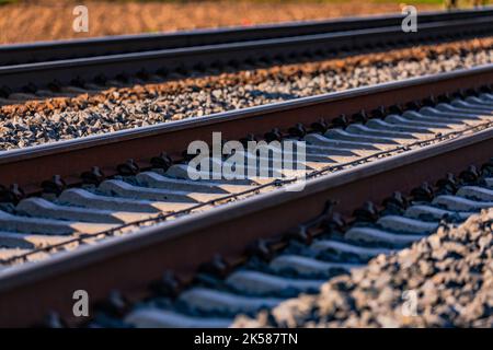 Traversine e rotaie con viti nel pianale dei cingoli con zavorra Foto Stock