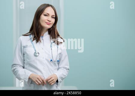 Il medico della signora sta in piedi nella stanza d'attesa che peering fuori per i nuovi arrivati Foto Stock