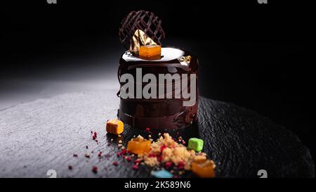Dessert al cioccolato su una pietra nera con decorazioni Foto Stock
