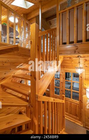 Ingresso ad una casa completamente in legno. Porta, ringhiere e lampade luminose in una piccola casa di campagna. Foto Stock