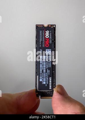 Parigi, Francia - 8 aprile 2022: Mano POV maschio disimballaggio disimballaggio nuovo Samsung 980 Pro NVME ss disco rigido per il personal computer o mac aggiornamento Apple Foto Stock