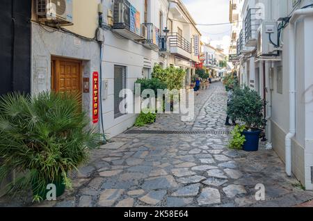 ESTEPONA, SPAGNA - 12 OTTOBRE 2021: Stradine strette nel centro di Estepona, tipica cittadina andalusa, con case bianche adornate da fiori colorati Foto Stock