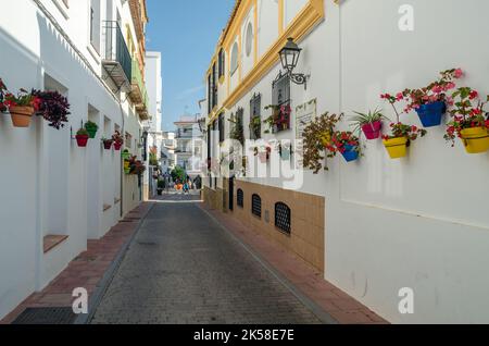 ESTEPONA, SPAGNA - 12 OTTOBRE 2021: Stradine strette nel centro di Estepona, tipica cittadina andalusa, con case bianche adornate da fiori colorati Foto Stock