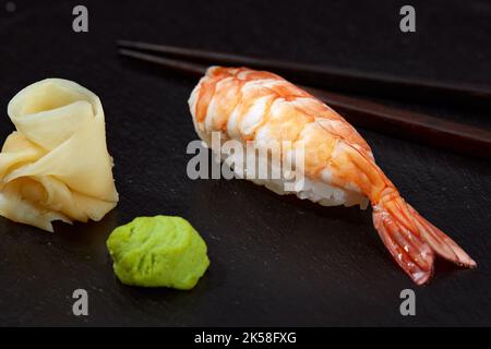 Nigiri di gamberi rossi crudi fotografati dall'alto su lavagna nera, cucina giapponese Foto Stock