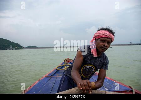 un povero uomo tribale che tira la barca con la mano con la pagaia Foto Stock