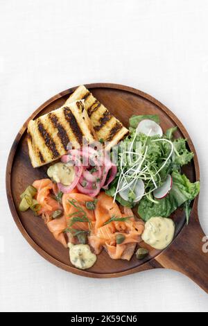 piatto di salmone gravlax con insalata e toast su sfondo bianco in svezia Foto Stock