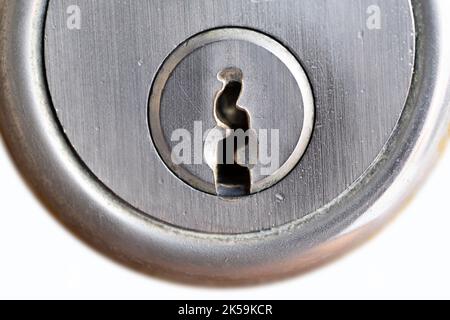 Piastra di metallo con foro per chiave di una serratura a cilindro in una porta. Isolato su sfondo bianco Foto Stock