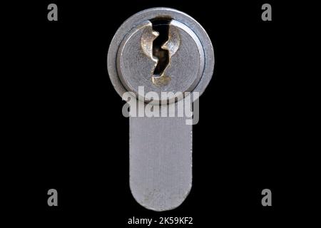 Piastra di metallo con foro per chiave di una serratura a cilindro in una porta. Isolato su sfondo nero Foto Stock