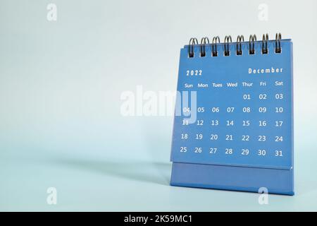 Focalizzazione selettiva del calendario da tavolo di dicembre 2022 su sfondo blu con albero di natale e spazio copia. Foto Stock