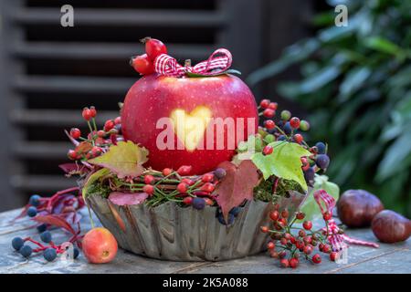 mela con cuore ornamento in vecchia teglia da forno come decorazione autunnale Foto Stock