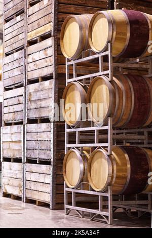 Molte parti costituiscono il processo di produzione. Botti di legno in una cantina di produttori di vino. Foto Stock