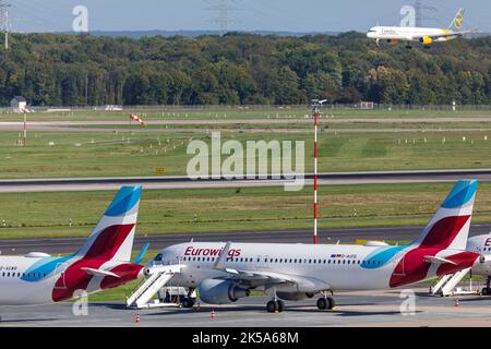 Aeroporto di Düsseldorf - aeromobile Eurowings in posizione di parcheggio durante lo sciopero dei piloti, aeromobile passeggeri Condor in avvicinamento per l'atterraggio Foto Stock