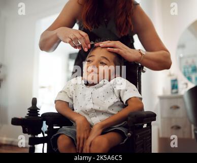 Taglio di capelli, bisogni speciali e paralisi cerebrale al parrucchiere con un sorriso. Bambino felice con una condizione di salute che ottiene un rivestimento del salone dei capelli da a. Foto Stock