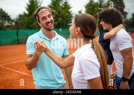 Gruppo di giocatori di tennis che danno una stretta di mano dopo una partita Foto Stock