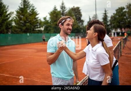 Gruppo di giocatori di tennis che danno una stretta di mano dopo una partita Foto Stock